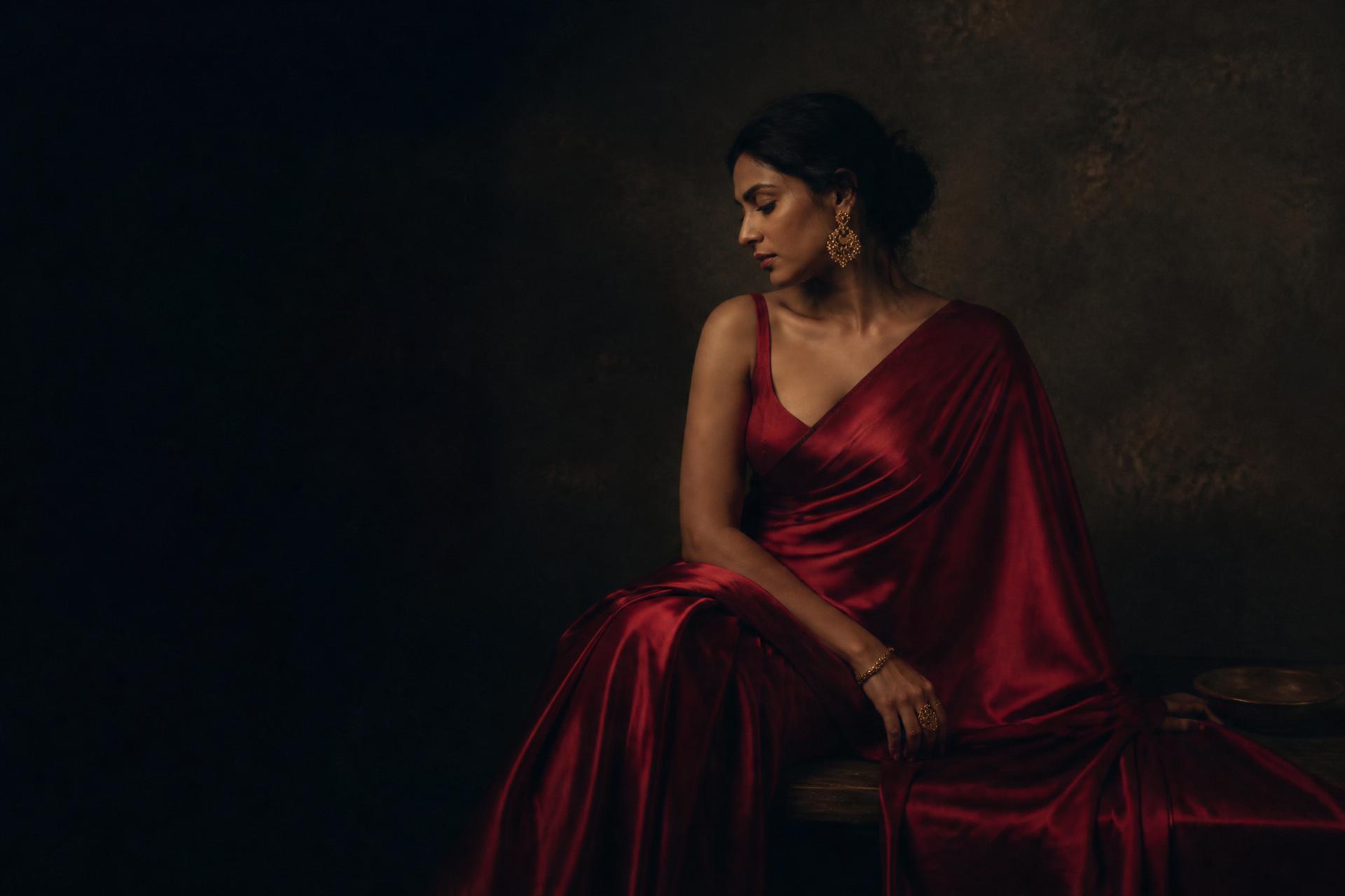 A woman draped in a handwoven silk saree in low warm light